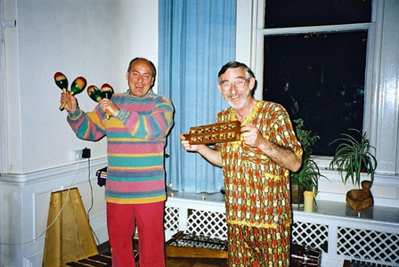 Radio Show Tribute Dance! Two men in brightly patterned shirts holding maracas and another instrument while dancing.